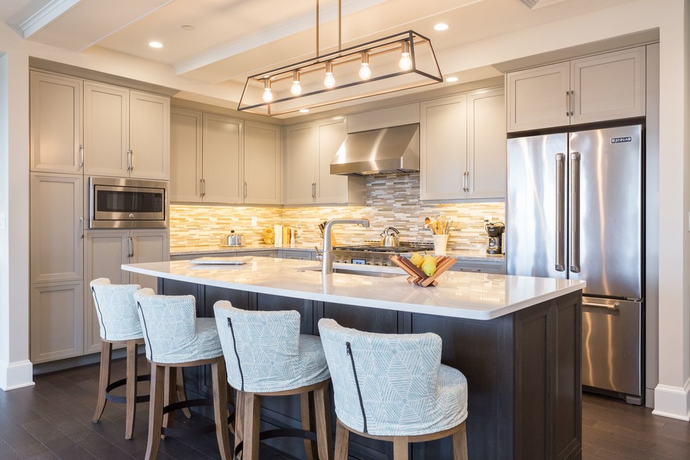 Open concept kitchen - transitional l-shaped dark wood floor open concept kitchen idea in Boston with a single-bowl sink, recessed-panel cabinets, beige cabinets, quartzite countertops, multicolored backsplash, matchstick tile backsplash, stainless steel appliances and an island