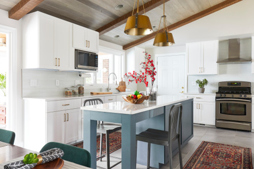 Blue Kitchen Island with White Countertop in a Farmhouse White Kitchen Cabinets with Gray Chairs