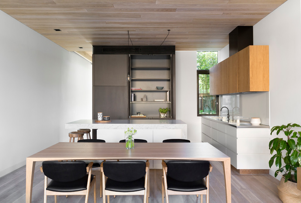 Свежая идея для дизайна: п-образная кухня в скандинавском стиле с обеденным столом, плоскими фасадами, белыми фасадами и островом - отличное фото интерьера