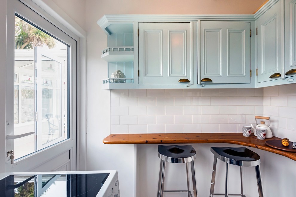 Photo of a small victorian u-shaped kitchen pantry in Dublin with a built-in sink, beaded cabinets, turquoise cabinets, wood worktops, white splashback, ceramic splashback, white appliances, laminate floors, no island, grey floors and white worktops.
