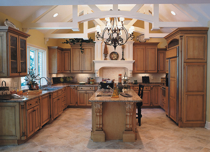 Foto på ett stort medelhavsstil u-kök, med en undermonterad diskho, luckor med upphöjd panel, skåp i mellenmörkt trä, granitbänkskiva, beige stänkskydd, stänkskydd i stenkakel, integrerade vitvaror, klinkergolv i keramik, en köksö och brunt golv