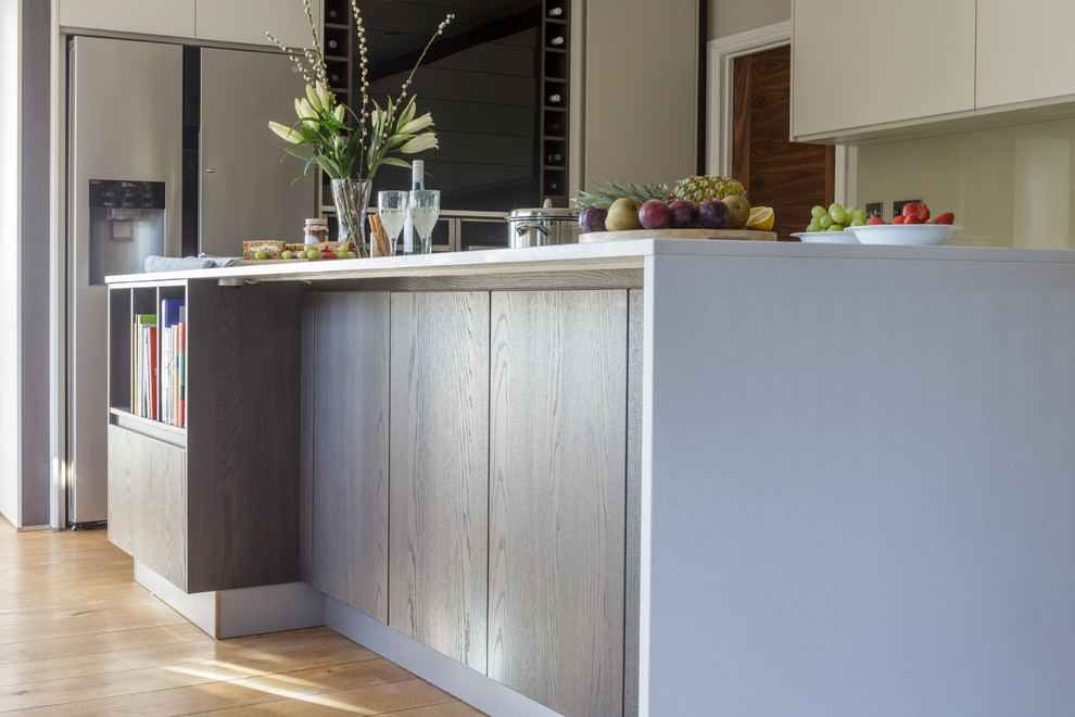Esempio di una cucina minimal con lavello sottopiano, top in quarzite, elettrodomestici neri e pavimento in legno massello medio
