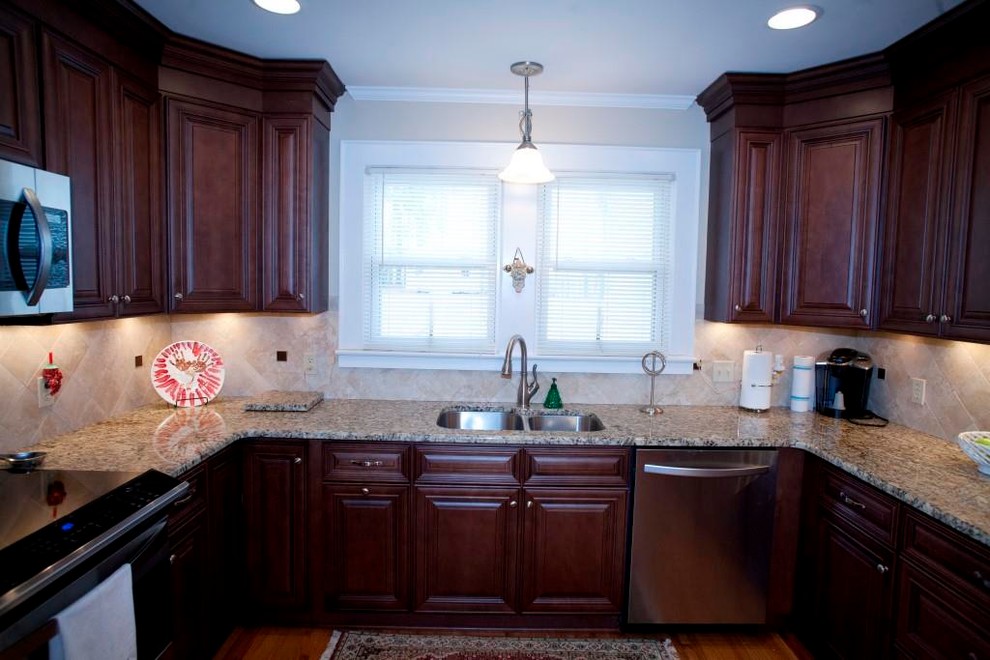 Eat-in kitchen - transitional u-shaped eat-in kitchen idea in Charlotte with an undermount sink, raised-panel cabinets, dark wood cabinets, granite countertops, beige backsplash, subway tile backsplash and stainless steel appliances
