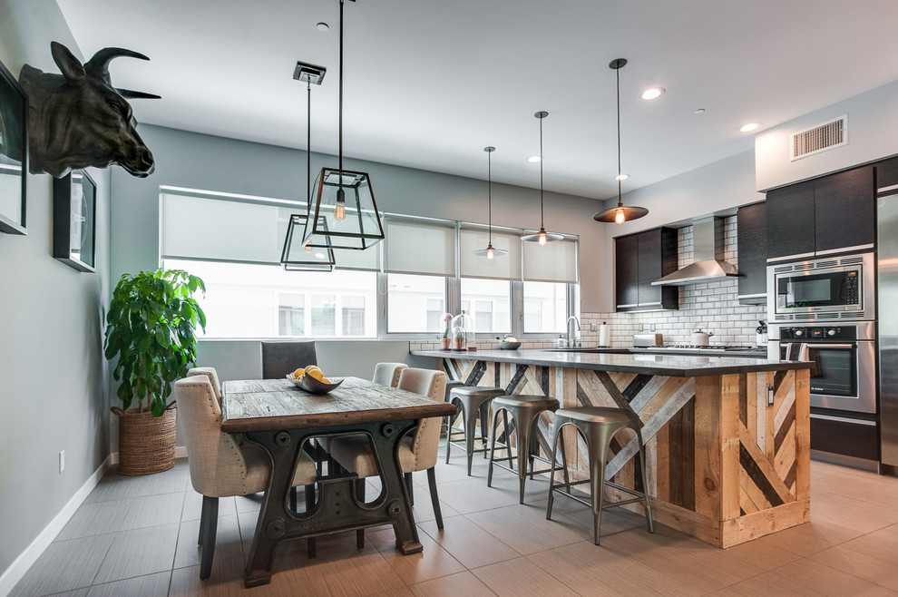 Eat-in kitchen - industrial u-shaped porcelain tile eat-in kitchen idea in Los Angeles with a drop-in sink, flat-panel cabinets, quartz countertops, white backsplash, ceramic backsplash, stainless steel appliances and an island
