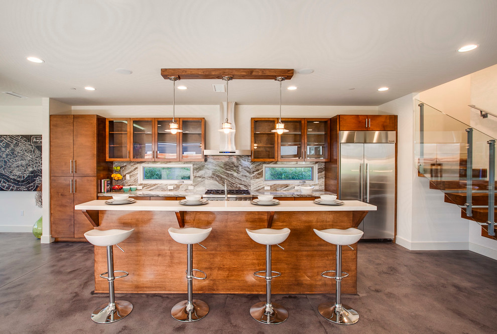 This is an example of a contemporary kitchen in Los Angeles with glass-front cabinets, medium wood cabinets, multi-coloured splashback, stainless steel appliances, concrete flooring and an island.