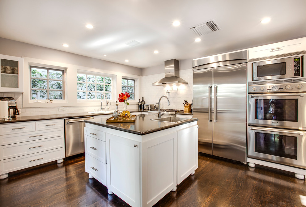 Inspiration for a classic kitchen in Los Angeles with a built-in sink, shaker cabinets, white cabinets, white splashback, metro tiled splashback and stainless steel appliances.