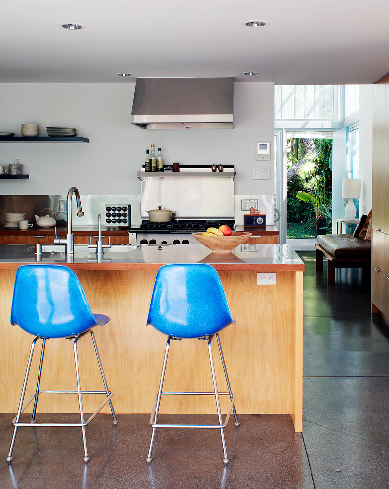 Cette photo montre une cuisine moderne avec un plan de travail en inox, une crédence métallisée et une crédence en dalle métallique.