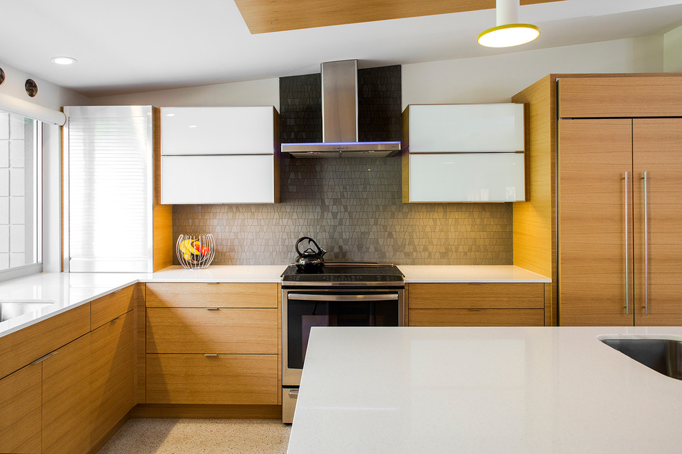 Retro Küche in L-Form mit flächenbündigen Schrankfronten, hellen Holzschränken, Küchenrückwand in Grau, Rückwand aus Glasfliesen, Betonboden und Kücheninsel in Tampa