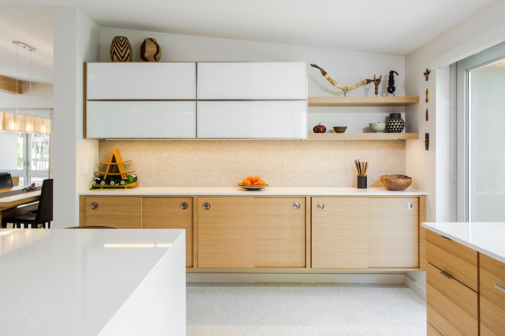 Retro Küche in L-Form mit flächenbündigen Schrankfronten, hellen Holzschränken, Küchenrückwand in Grau, Rückwand aus Glasfliesen, Betonboden und Kücheninsel in Tampa