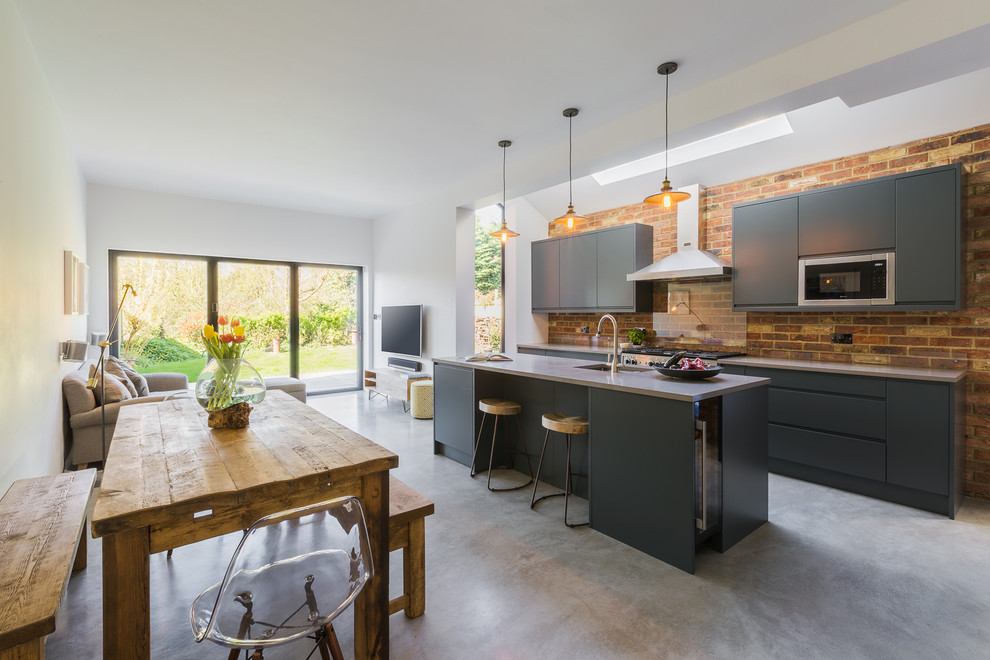 Photo of a large contemporary single-wall open plan kitchen in London with a submerged sink, flat-panel cabinets, grey cabinets, concrete worktops, stainless steel appliances, concrete flooring, an island, grey floors and grey worktops.