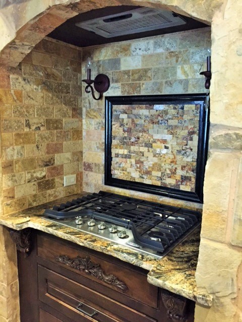 Medelhavsstil inredning av ett mellanstort kök, med en rustik diskho, luckor med infälld panel, skåp i mörkt trä, granitbänkskiva, flerfärgad stänkskydd, stänkskydd i mosaik, rostfria vitvaror, tegelgolv och en köksö