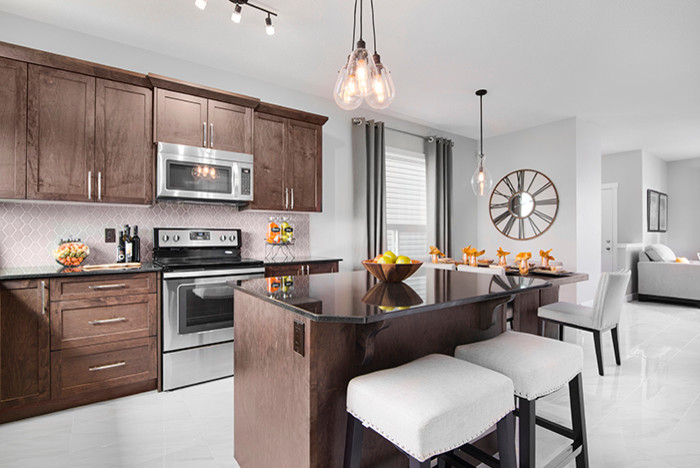 Photo of a medium sized contemporary l-shaped open plan kitchen in Calgary with shaker cabinets, medium wood cabinets, granite worktops, stainless steel appliances, ceramic flooring and an island.