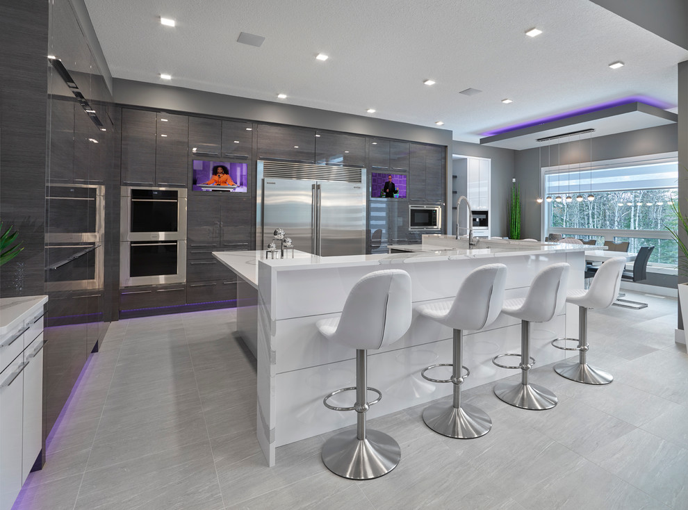 Trendy u-shaped porcelain tile eat-in kitchen photo in Edmonton with flat-panel cabinets, gray cabinets, quartzite countertops, white backsplash, porcelain backsplash, stainless steel appliances and an island