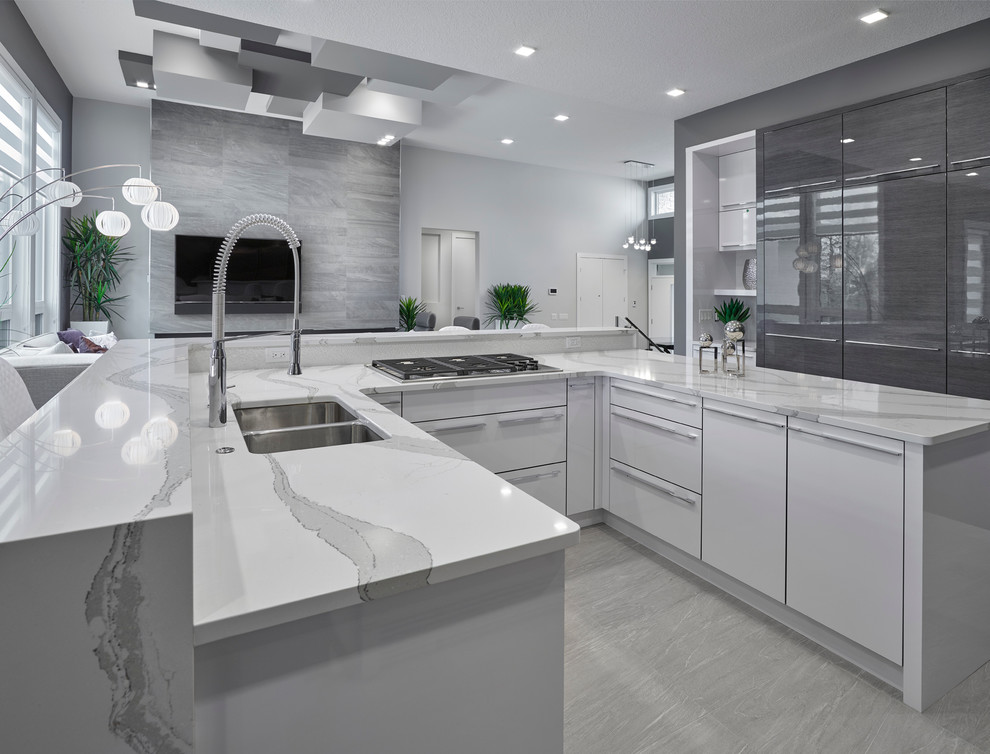 Exempel på ett modernt kök, med en undermonterad diskho, släta luckor, grå skåp, bänkskiva i kvartsit, vitt stänkskydd, stänkskydd i porslinskakel, rostfria vitvaror, klinkergolv i porslin och en köksö