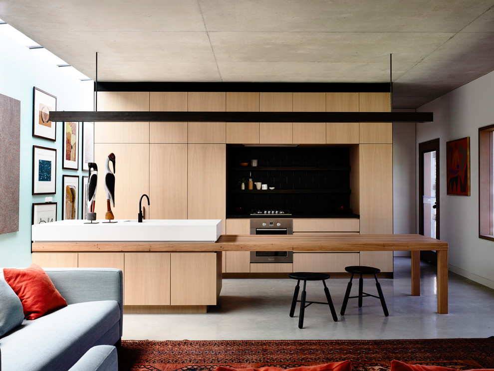 Идея дизайна: прямая кухня в современном стиле с плоскими фасадами, светлыми деревянными фасадами, деревянной столешницей, бетонным полом и островом