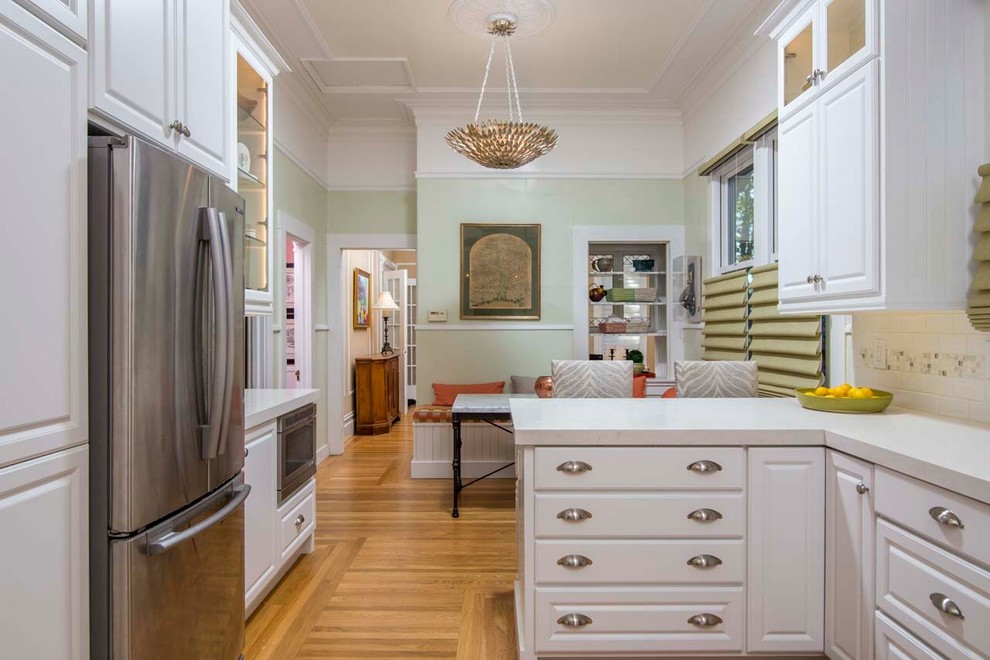 Foto på ett vintage l-kök, med rostfria vitvaror, ljust trägolv och beiget golv