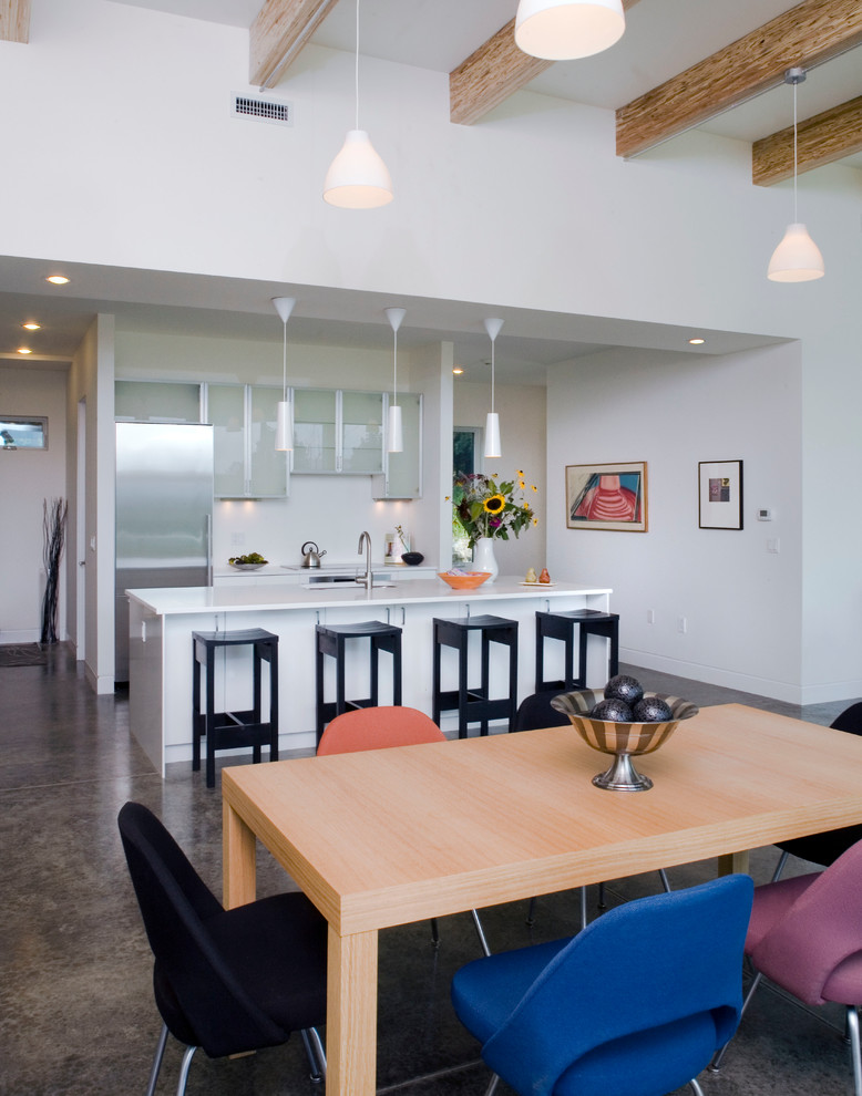 Photo of a modern galley kitchen/diner in New York with glass-front cabinets, stainless steel cabinets and stainless steel appliances.