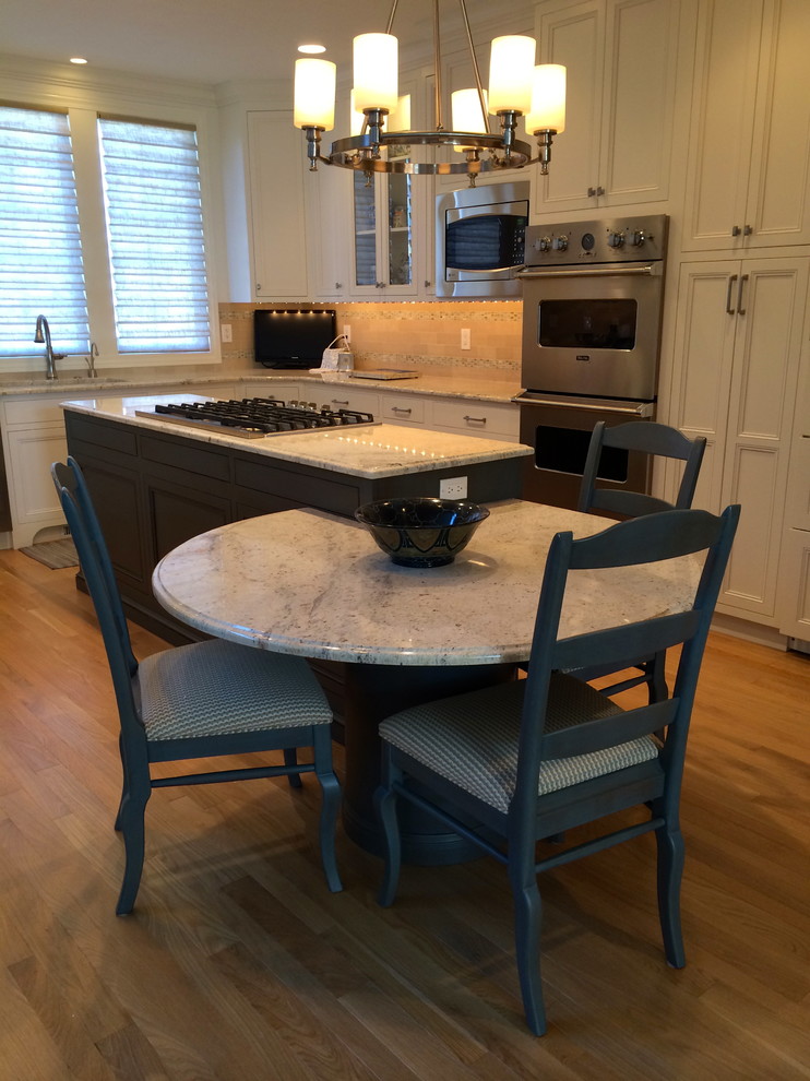 Eat-in kitchen - transitional u-shaped light wood floor and brown floor eat-in kitchen idea in Cleveland with an undermount sink, beaded inset cabinets, white cabinets, granite countertops, beige backsplash, mosaic tile backsplash, stainless steel appliances and an island
