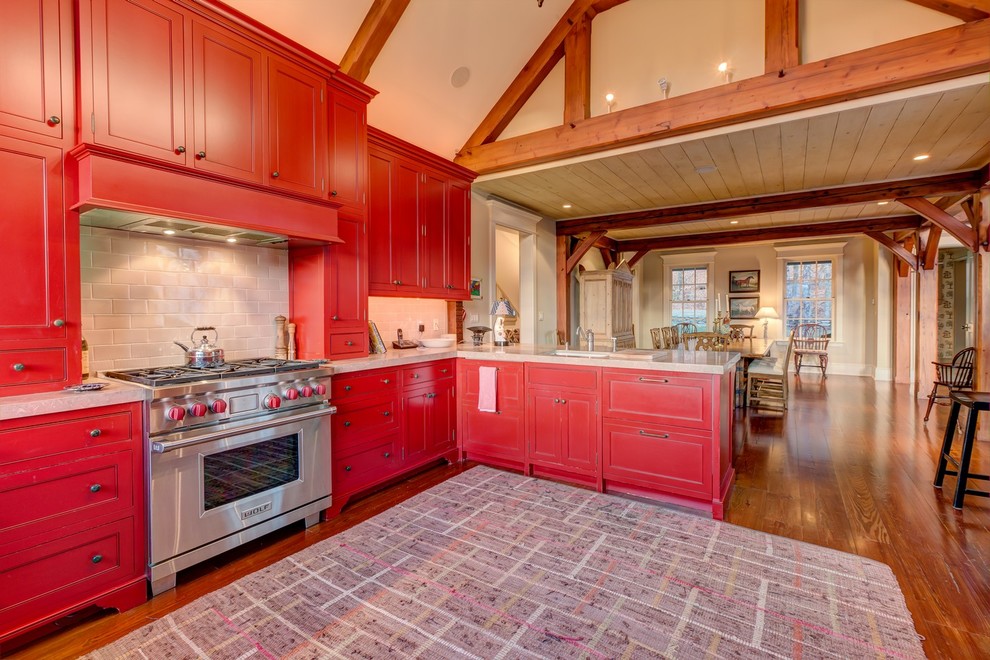Große Landhausstil Wohnküche in U-Form mit Schrankfronten im Shaker-Stil, roten Schränken und braunem Holzboden in Sonstige