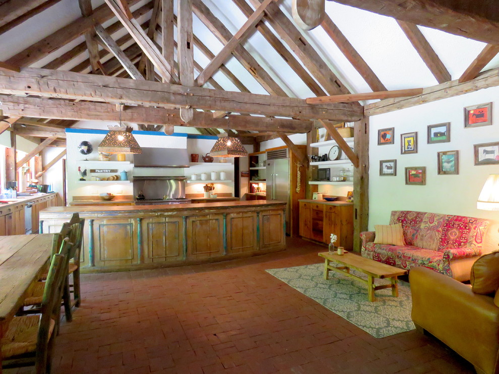 Immagine di un'ampia cucina stile americano con ante a filo, ante con finitura invecchiata, top in legno, paraspruzzi con piastrelle di metallo, pavimento in mattoni, pavimento rosso e top marrone