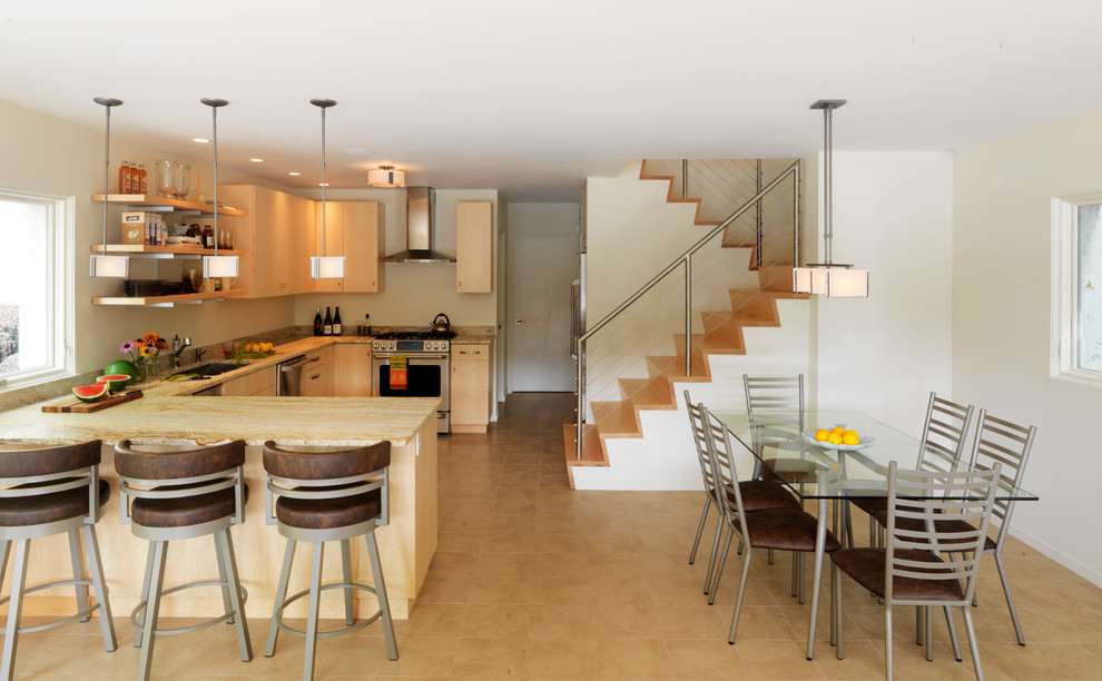 Moderne Wohnküche in U-Form mit Küchengeräten aus Edelstahl, flächenbündigen Schrankfronten und hellen Holzschränken in Burlington