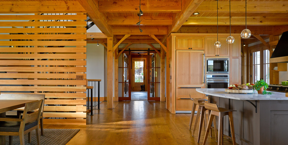 Foto på ett rustikt kök och matrum, med skåp i shakerstil, skåp i ljust trä, vitt stänkskydd, integrerade vitvaror och en köksö