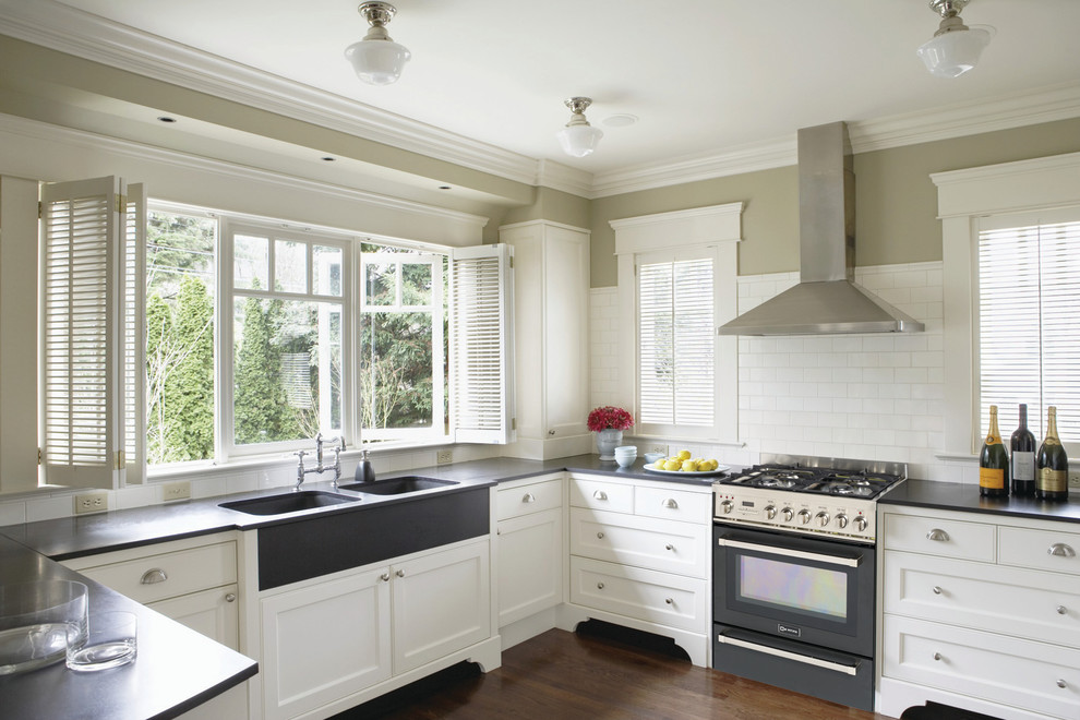 Inspiration for a transitional kitchen remodel in New York with subway tile backsplash, an integrated sink and black appliances