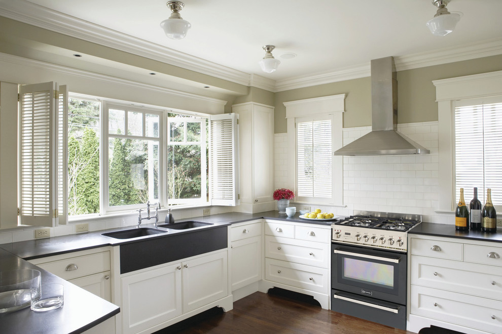 Design ideas for a traditional kitchen in New York with metro tiled splashback, an integrated sink and black appliances.