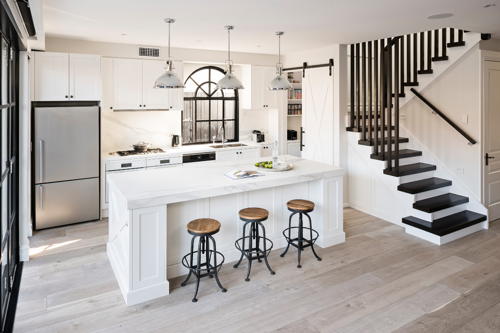 メルボルンにある高級な広いインダストリアルスタイルのおしゃれなキッチン (落し込みパネル扉のキャビネット、白いキャビネット、クオーツストーンカウンター、白いキッチンパネル) の写真
