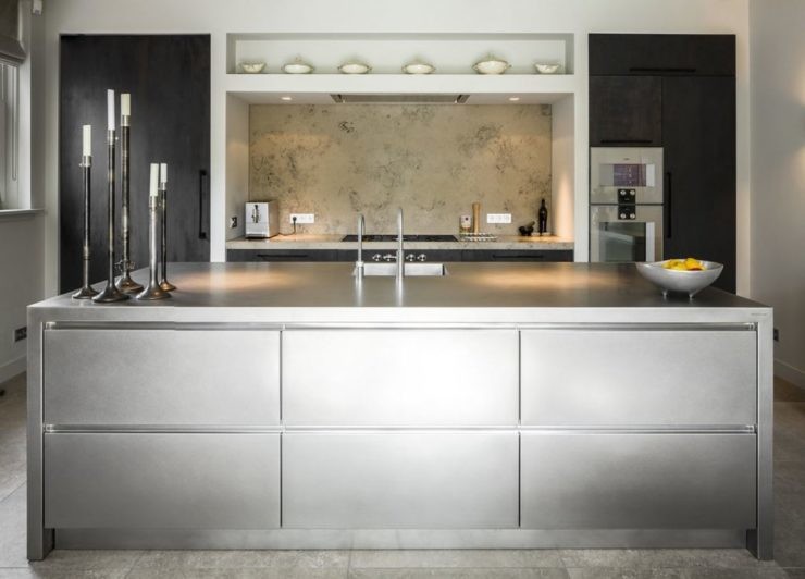 Foto di una grande cucina abitabile minimalista con top in acciaio inossidabile, elettrodomestici neri, paraspruzzi beige, 2 o più isole e top grigio
