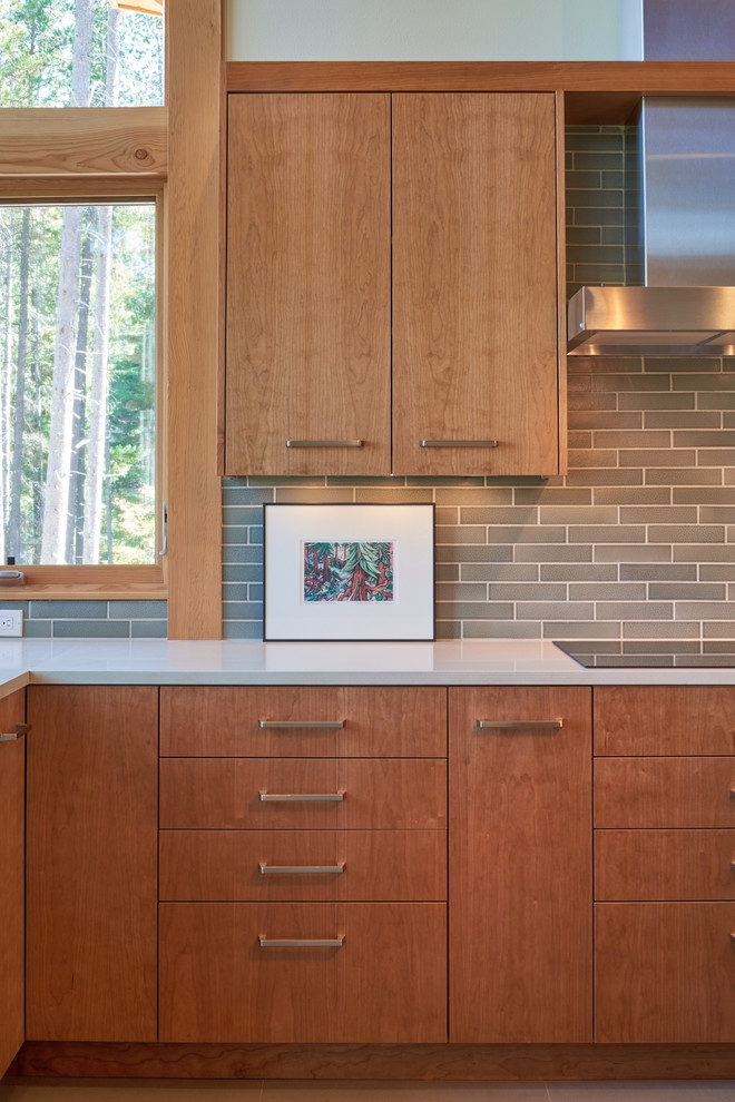 Inredning av ett modernt mellanstort kök, med en undermonterad diskho, släta luckor, skåp i mellenmörkt trä, bänkskiva i koppar, grått stänkskydd, stänkskydd i keramik, rostfria vitvaror, betonggolv och en köksö