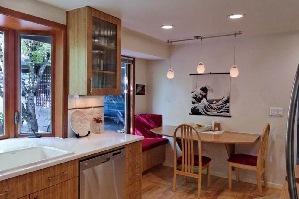 Eat-in kitchen - mid-sized asian u-shaped light wood floor eat-in kitchen idea in Portland with a drop-in sink, flat-panel cabinets, medium tone wood cabinets, quartz countertops, white backsplash, subway tile backsplash, stainless steel appliances and no island