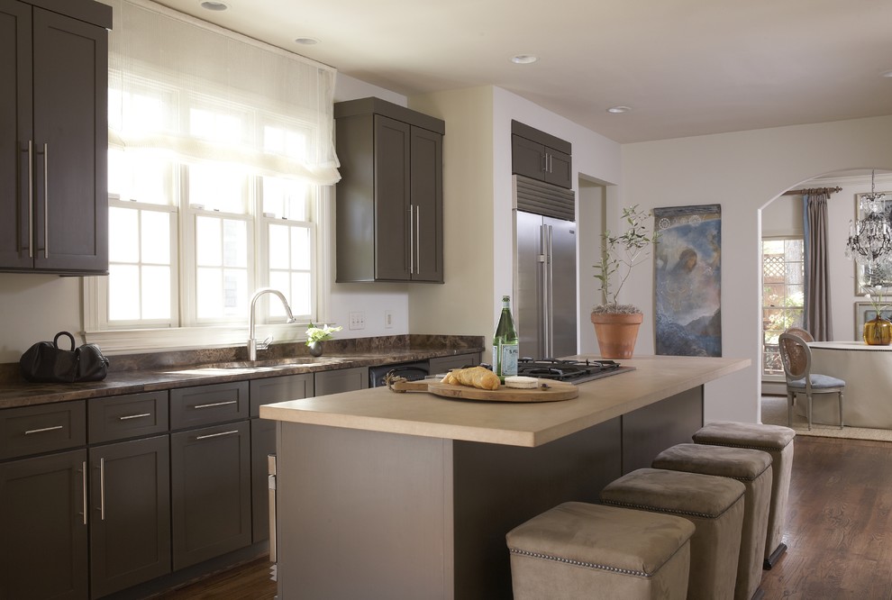 Foto de cocina actual con armarios estilo shaker, puertas de armario grises, encimera de piedra caliza, electrodomésticos de acero inoxidable y barras de cocina