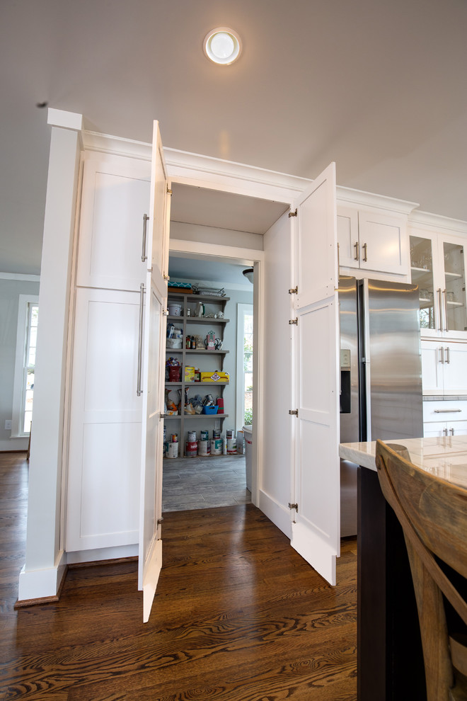 Example of a large transitional u-shaped medium tone wood floor kitchen pantry design in Birmingham with white cabinets, stainless steel appliances, an island, an undermount sink, recessed-panel cabinets, quartzite countertops, beige backsplash and subway tile backsplash