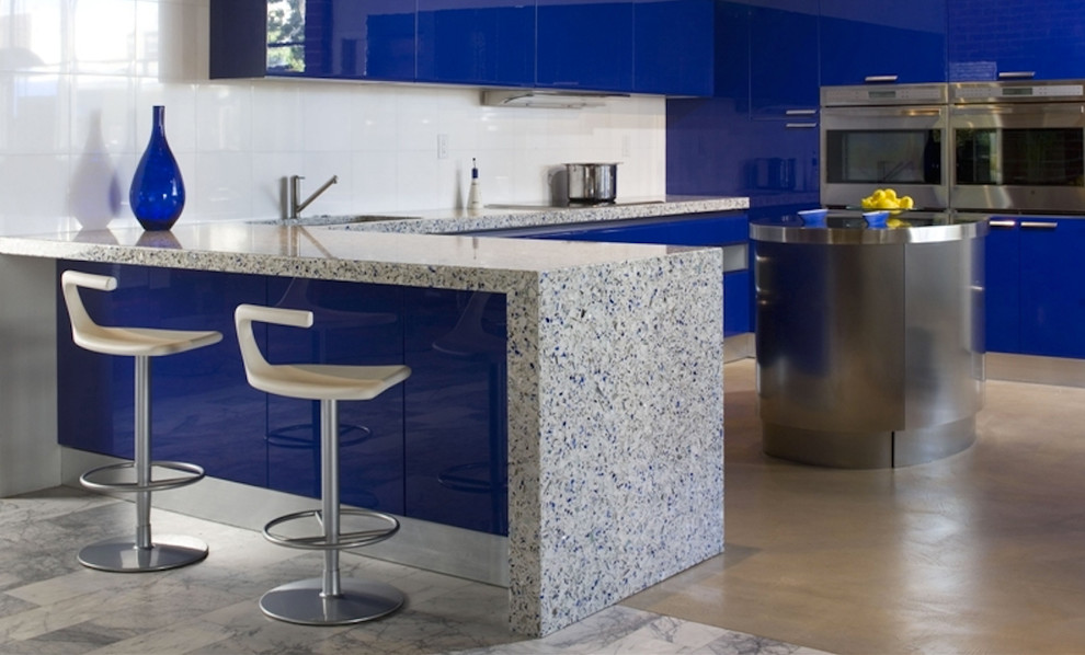 Ispirazione per una grande cucina a L minimalista con lavello sottopiano, ante lisce, ante blu, top in vetro riciclato, paraspruzzi bianco, paraspruzzi con piastrelle in ceramica, elettrodomestici in acciaio inossidabile e penisola