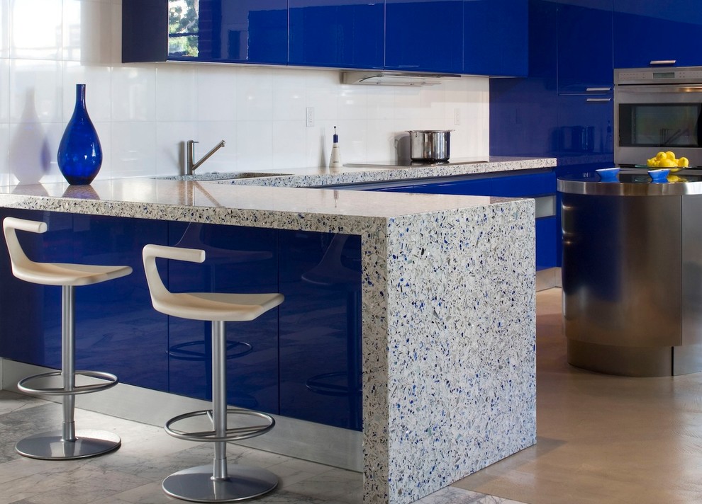 Modern kitchen/diner in DC Metro with recycled glass countertops and white splashback.