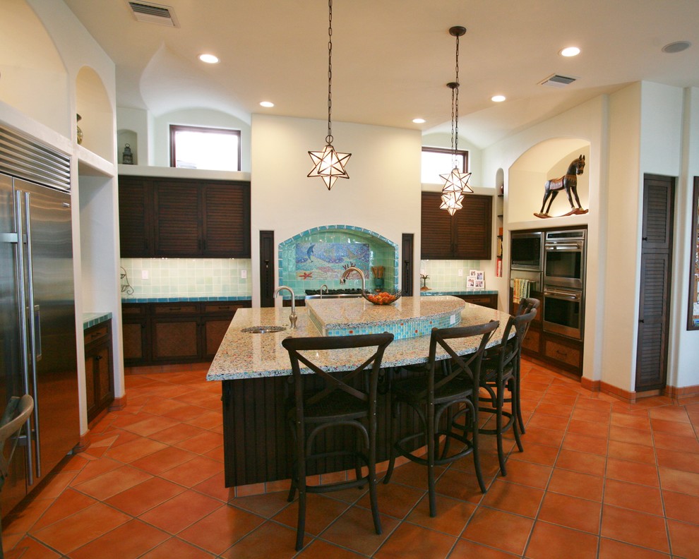 Contemporary kitchen in Tampa with stainless steel appliances, recycled glass countertops and green splashback.