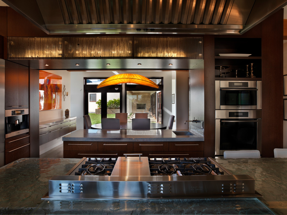 Esempio di un'ampia cucina design con lavello sottopiano, ante lisce, ante in legno bruno, top in marmo, elettrodomestici in acciaio inossidabile e pavimento in pietra calcarea