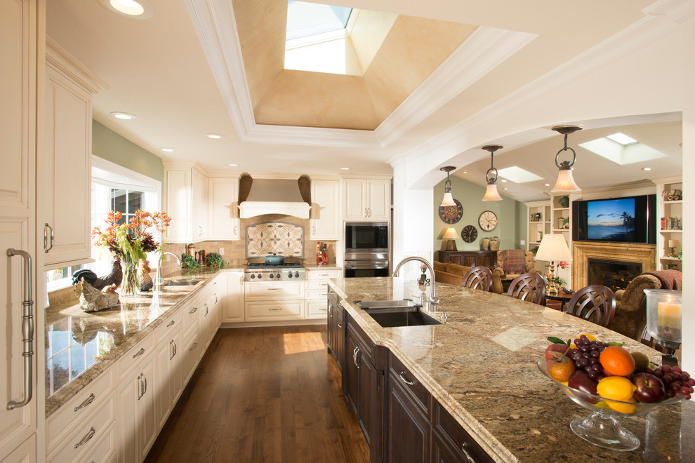 Inspiration for a huge timeless open concept kitchen remodel in San Francisco with an undermount sink, raised-panel cabinets, beige cabinets, granite countertops, multicolored backsplash, stainless steel appliances and an island