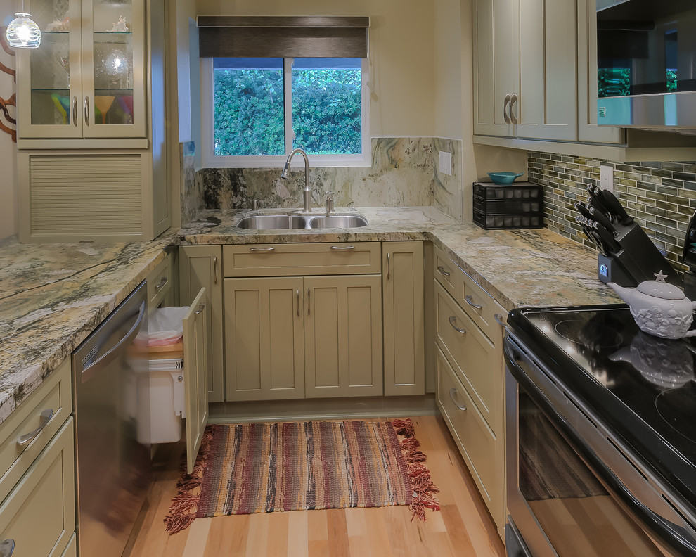 Bild på ett litet maritimt kök, med en undermonterad diskho, skåp i shakerstil, grå skåp, granitbänkskiva, flerfärgad stänkskydd, stänkskydd i stickkakel, rostfria vitvaror, ljust trägolv, en halv köksö och brunt golv