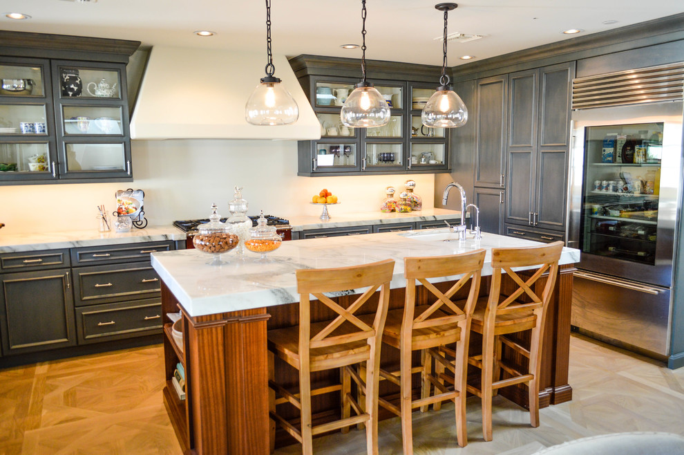 Eat-in kitchen - large traditional u-shaped light wood floor eat-in kitchen idea in Phoenix with a farmhouse sink, glass-front cabinets, blue cabinets, marble countertops, stainless steel appliances and an island