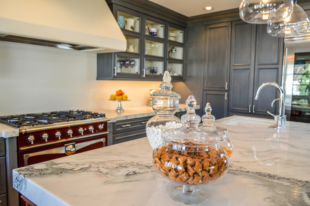 Example of a large classic u-shaped light wood floor eat-in kitchen design in Phoenix with a farmhouse sink, glass-front cabinets, blue cabinets, marble countertops, stainless steel appliances and an island