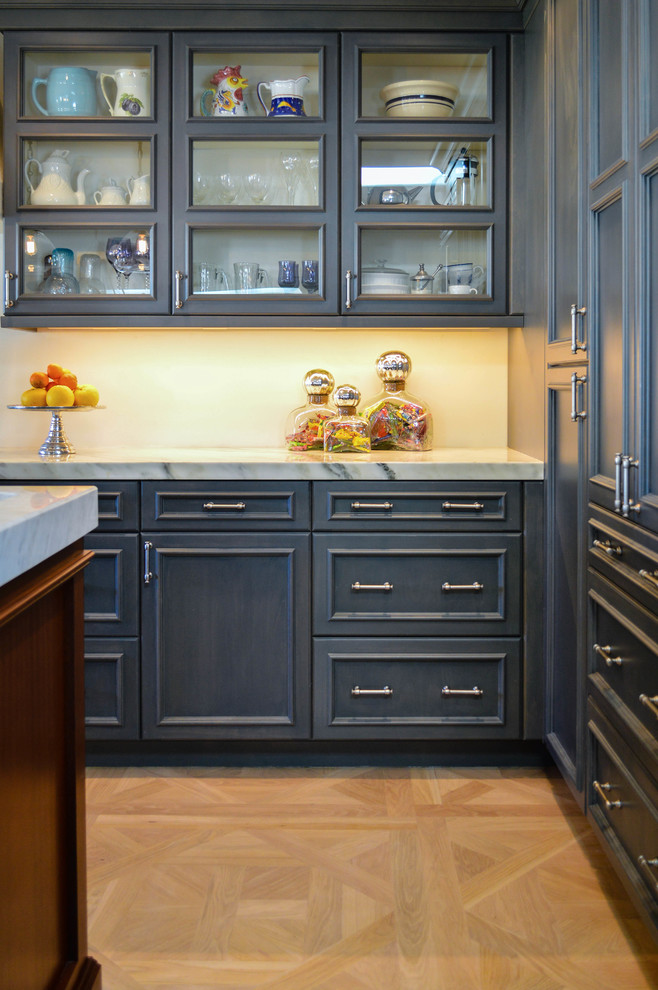 Example of a large classic u-shaped light wood floor eat-in kitchen design in Phoenix with a farmhouse sink, glass-front cabinets, blue cabinets, marble countertops, stainless steel appliances and an island