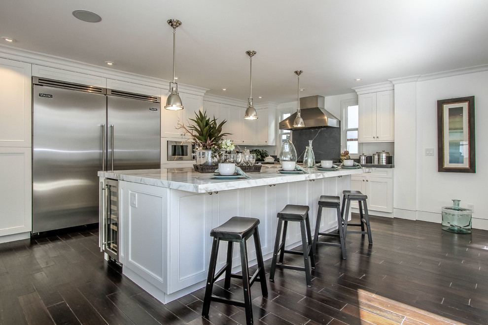 Inspiration for a timeless l-shaped open concept kitchen remodel in Orange County with a single-bowl sink, shaker cabinets, white cabinets, marble countertops, gray backsplash, stone slab backsplash and stainless steel appliances