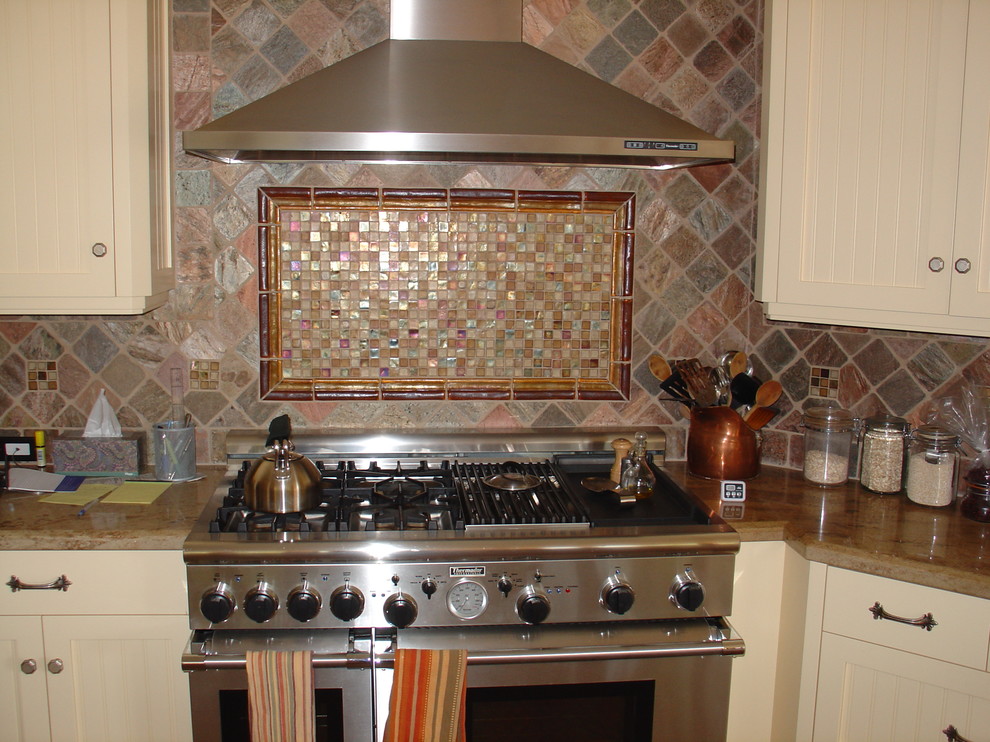 Eat-in kitchen - large mediterranean l-shaped terra-cotta tile eat-in kitchen idea in San Diego with an undermount sink, beaded inset cabinets, yellow cabinets, granite countertops, gray backsplash, stone tile backsplash, stainless steel appliances and an island