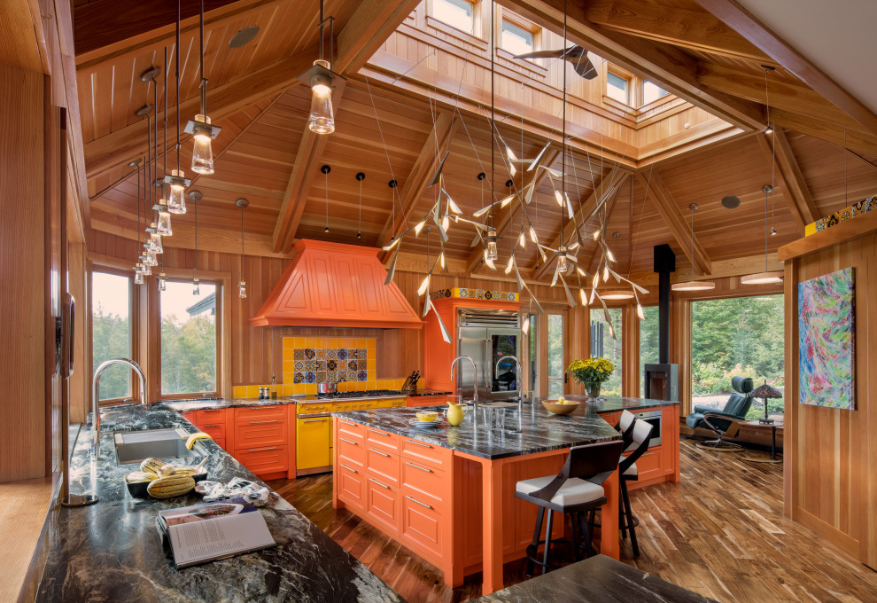 Moderne Küche in L-Form mit Schrankfronten mit vertiefter Füllung, orangefarbenen Schränken, bunten Elektrogeräten, braunem Holzboden, Kücheninsel, braunem Boden, grauer Arbeitsplatte, gewölbter Decke und Holzdecke in Burlington
