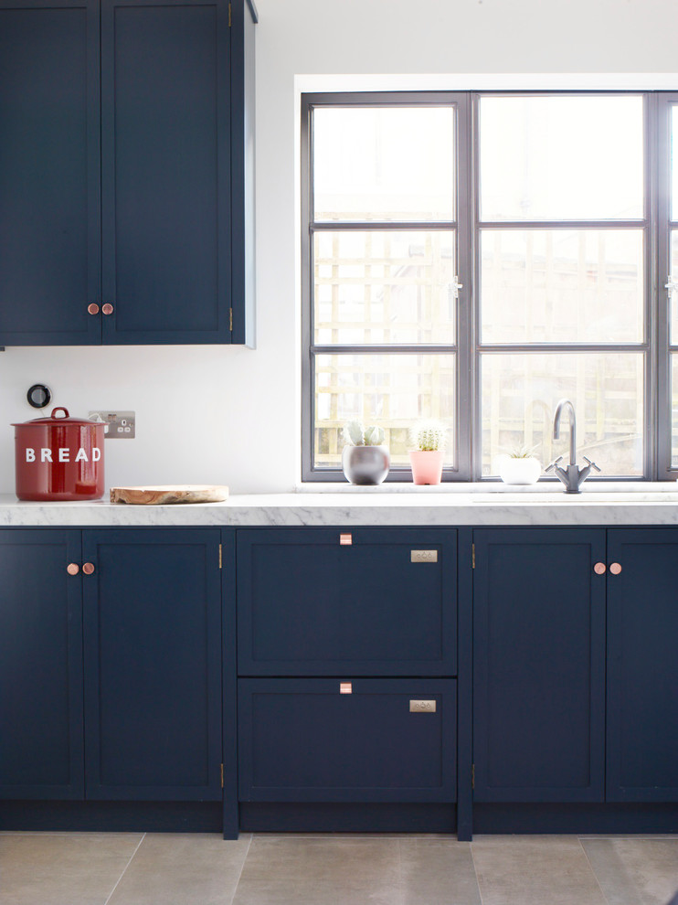 Ispirazione per una cucina contemporanea di medie dimensioni con lavello integrato, ante in stile shaker, ante blu, top in marmo, elettrodomestici in acciaio inossidabile, pavimento con piastrelle in ceramica e pavimento grigio