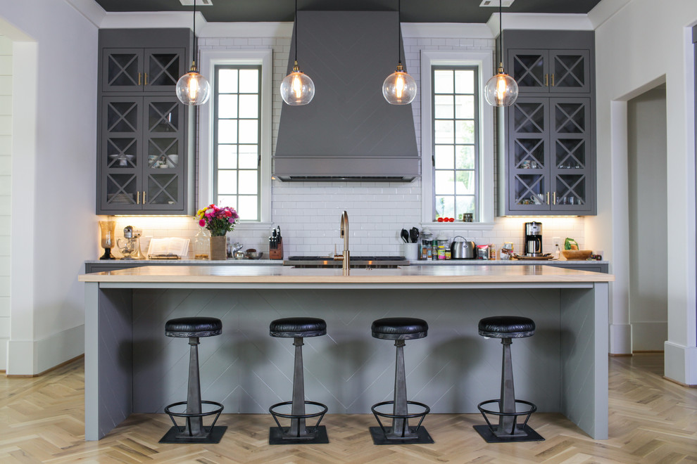 Klassische Küche mit Glasfronten, grauen Schränken, Küchenrückwand in Weiß, Rückwand aus Metrofliesen, hellem Holzboden und Kücheninsel in Atlanta