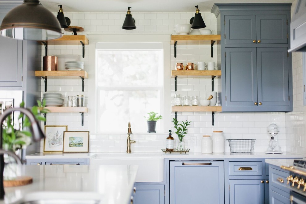 Inspiration för ett mellanstort vintage kök, med en rustik diskho, luckor med infälld panel, blå skåp, bänkskiva i kvarts, vitt stänkskydd, stänkskydd i tunnelbanekakel, integrerade vitvaror, mörkt trägolv, en köksö och brunt golv