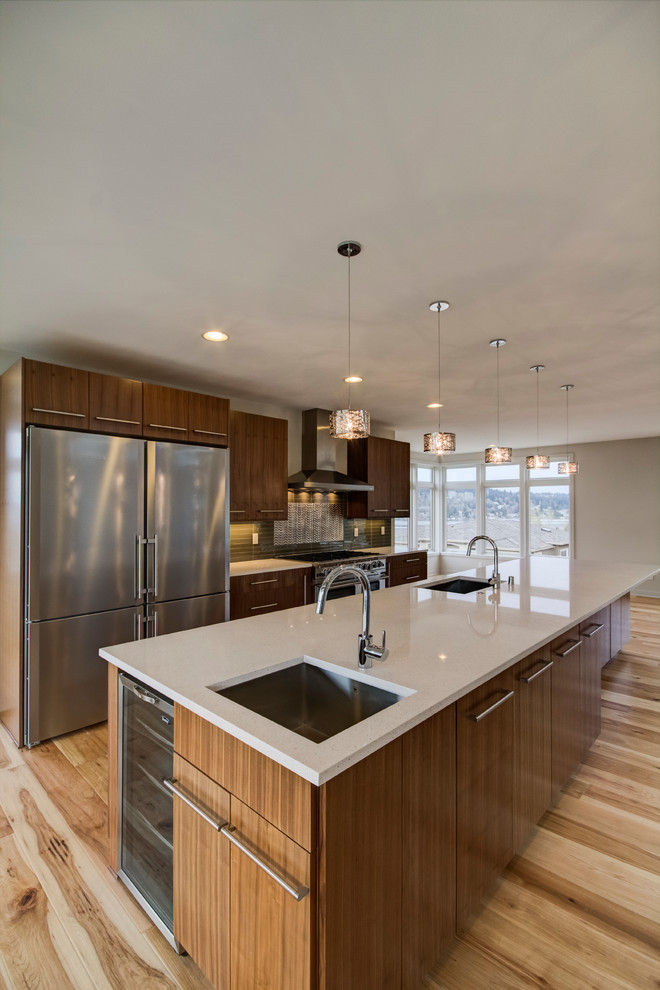 Large trendy galley light wood floor and brown floor eat-in kitchen photo in Seattle with an undermount sink, flat-panel cabinets, dark wood cabinets, quartz countertops, green backsplash, subway tile backsplash, stainless steel appliances and an island